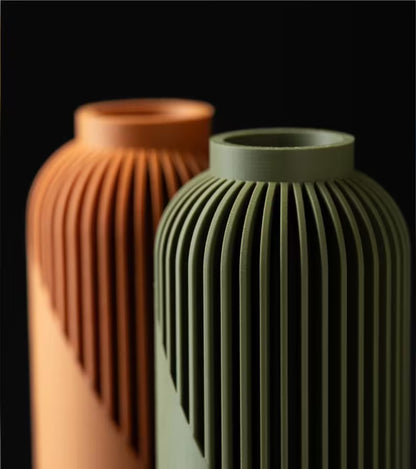 Due vasi decorativi moderni con scanalature verticali in colori verde e terracotta