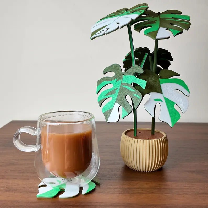 Pianta decorativa Monstera in vaso con tazza di caffè su superficie in legno