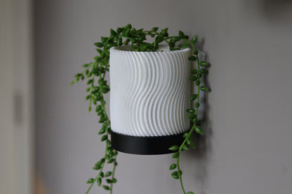 Vaso da parete bianco con motivo ondulato e pianta ricadente verde