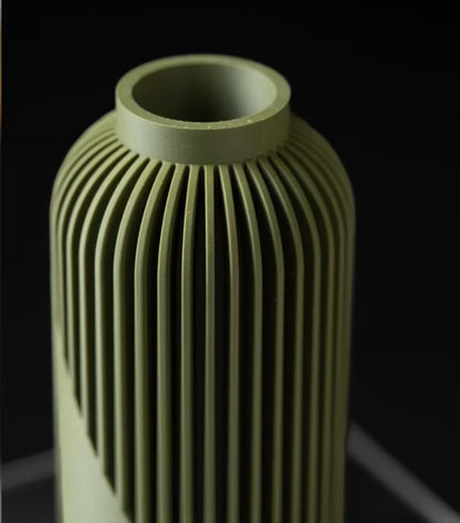 Vaso decorativo verde oliva con scanalature verticali su sfondo scuro